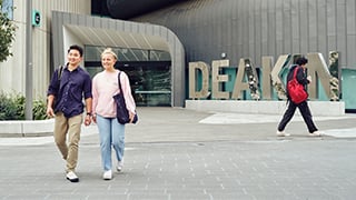 Two high school students walking out of the Deakin Law building