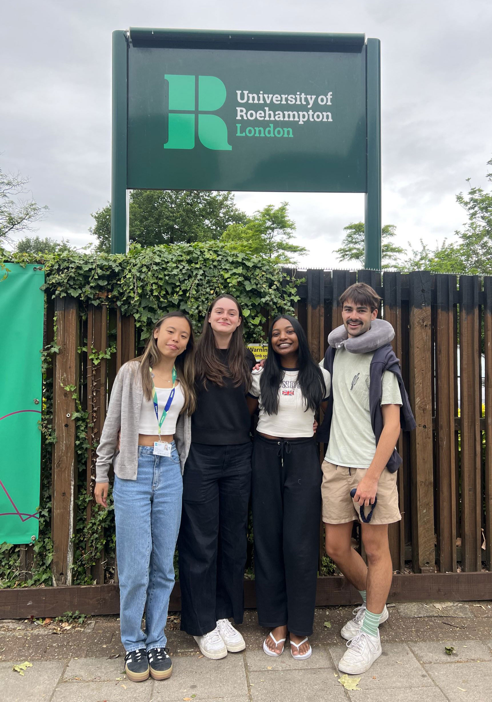 Ethan and friends stand in front of the University of Roehampton sign