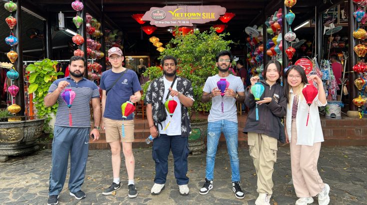 Student Taha and friends outside a silk shop holding lanterns