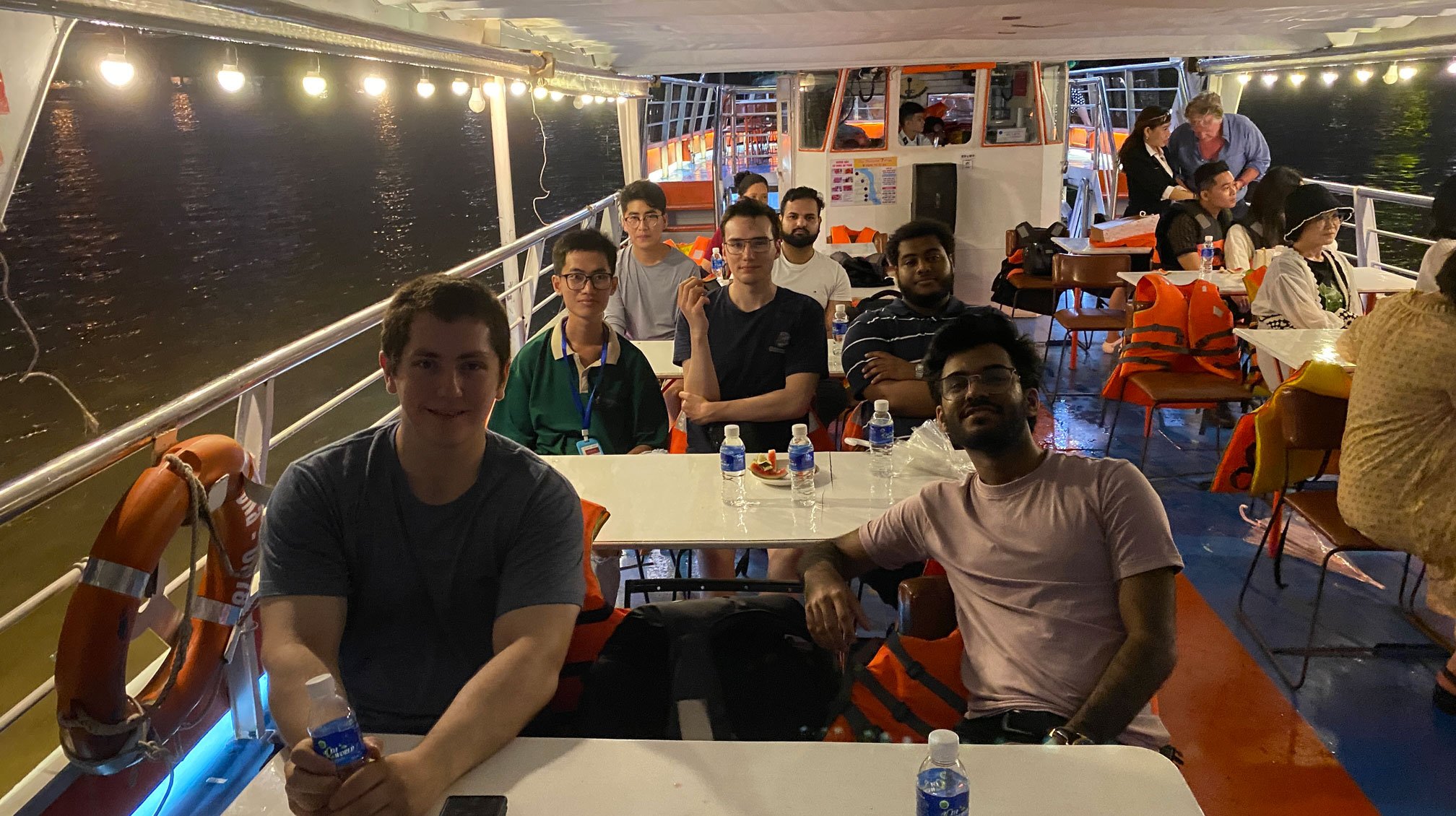 A group of students on a nighttime scenic boat ride