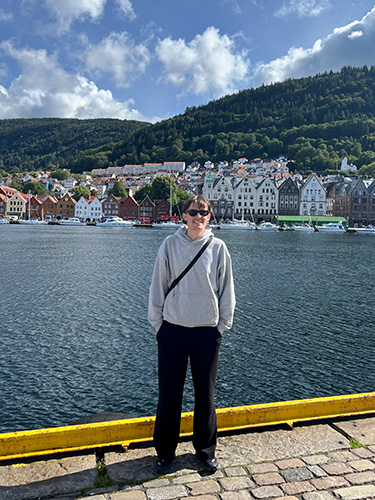 Student Zachary in front of the water, houses and mountains in Norway